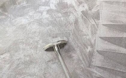 Technician cleaning grey carpet with a hot water extraction wand