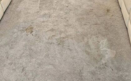 Grey carpet with visible spots and traffic soiling before treatment